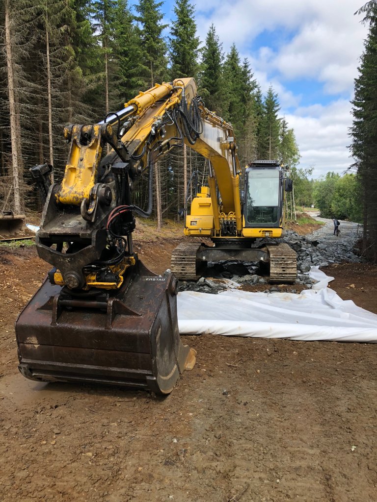 Bildet viser skogsvei med en traktor   Foto Landbruksdirektoratet