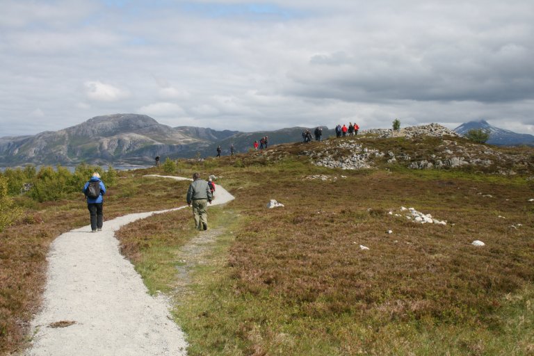 Ut på tur. Tursti i fjellområde med lyng omkring stien og grå fjell i bakgrunnen. Skeisnesset, Leka. Foto: Ragnhild hoel 