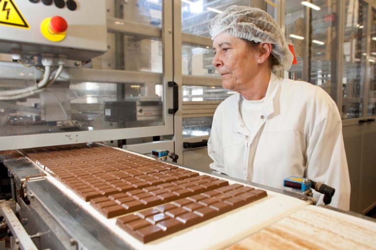 Matvarefabrikk med maskin som produserer sjokoladeplater.